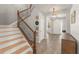 Bright foyer with staircase, decorative wreath and lettering, tile flooring, and elegant lighting at 10720 Breaking Rocks Dr, Tampa, FL 33647