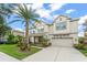 Stunning two-story home boasts a well-manicured lawn and beautiful landscaping including a mature palm tree at 10720 Breaking Rocks Dr, Tampa, FL 33647