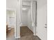 Hallway with white walls, tiled floors, decorative curtains, and doorway leading into the main bathroom with a tub and toilet at 10720 Breaking Rocks Dr, Tampa, FL 33647