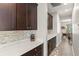 Hallway view of kitchen area with dark wood cabinets and white countertops at 10720 Breaking Rocks Dr, Tampa, FL 33647
