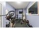 Well-equipped home gym with modern fitness machines and weights for full-body workout and a large window for natural light at 10720 Breaking Rocks Dr, Tampa, FL 33647