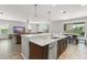 Open floor plan showing the kitchen island with stainless appliances and quartz countertops, breakfast nook, and living room at 10720 Breaking Rocks Dr, Tampa, FL 33647