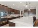 Modern kitchen features stainless appliances, dark cabinetry, island with quartz countertops, and bar stool seating at 10720 Breaking Rocks Dr, Tampa, FL 33647