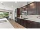 Bright kitchen with stainless steel appliances, dark cabinetry, quartz countertops, and a view to the breakfast nook at 10720 Breaking Rocks Dr, Tampa, FL 33647