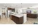 Bright kitchen with stainless appliances, dark cabinetry, quartz countertops, and open floor plan into the living room at 10720 Breaking Rocks Dr, Tampa, FL 33647