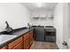 Functional laundry room with modern washer and dryer, ample counter space, and storage for efficient laundry tasks at 10720 Breaking Rocks Dr, Tampa, FL 33647