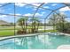 Sparkling pool area with a spa and views of lake, complemented by tropical landscaping, perfect for backyard activities at 10720 Breaking Rocks Dr, Tampa, FL 33647