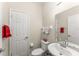 Compact powder room with a white toilet, small sink, and towel rack, great for guests visiting the home at 10720 Breaking Rocks Dr, Tampa, FL 33647