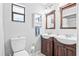 Bathroom featuring double sinks, wooden cabinets, and a separate toilet area at 1302 Georgetowne Cir, Sarasota, FL 34232