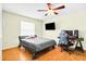 Bedroom with ceiling fan, hardwood floors, a black TV, a computer, and a computer chair at 1302 Georgetowne Cir, Sarasota, FL 34232