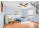 Bedroom featuring hardwood floors, a ceiling fan, and bright blue painted walls at 1302 Georgetowne Cir, Sarasota, FL 34232