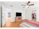 Bedroom featuring wood floors, ceiling fan, and an open doorway to an adjoining room at 1302 Georgetowne Cir, Sarasota, FL 34232
