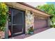 Attached garage with a multi-paneled door and stone accents; an entrance door is beside the garage at 1302 Georgetowne Cir, Sarasota, FL 34232