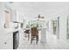 Bright kitchen with white cabinets, tile floors, breakfast bar, and a seamless transition to a large living space at 1302 Georgetowne Cir, Sarasota, FL 34232