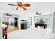 Open-concept area with tile flooring and multiple ceiling fans, adjacent to kitchen at 1302 Georgetowne Cir, Sarasota, FL 34232