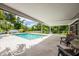 Spacious covered patio leads to a pristine pool surrounded by a large concrete deck at 1302 Georgetowne Cir, Sarasota, FL 34232
