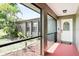 Screened-in porch features tiled flooring, neutral walls, and views of the front yard and property at 1302 Georgetowne Cir, Sarasota, FL 34232
