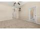 Carpeted bedroom with ceiling fan, neutral walls, and access to the lanai at 23109 Emerson Way, Land O Lakes, FL 34639