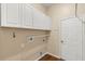 Bright laundry room with white cabinets and wood-look flooring at 23109 Emerson Way, Land O Lakes, FL 34639