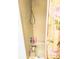 A bathtub with beige tiling and a pink floral shower curtain at 6640 121St Ave # 1, Largo, FL 33773