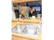 Stainless steel kitchen sink, butcher block counter with decor, and view into living space at 6640 121St Ave # 1, Largo, FL 33773