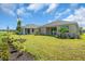The home features a spacious backyard lawn with well-maintained landscaping at 9581 Vibrant Lane, Venice, FL 34292