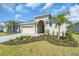 Attractive single-story home with a well-maintained lawn, lush landscaping, and a convenient two-car garage at 9581 Vibrant Lane, Venice, FL 34292