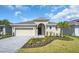 Charming single-story home with manicured landscaping, inviting entrance, paved driveway, and attached two-car garage at 9581 Vibrant Lane, Venice, FL 34292