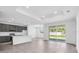 Well-lit kitchen with gray cabinets and stainless appliances in a spacious open floor plan, featuring sliding glass doors at 9581 Vibrant Lane, Venice, FL 34292
