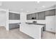 Modern kitchen features gray cabinetry, a white island, and stainless steel appliances, perfect for any chef at 9581 Vibrant Lane, Venice, FL 34292