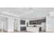 Bright, open kitchen boasts sleek gray cabinetry, a large center island, and modern stainless steel appliances at 9581 Vibrant Lane, Venice, FL 34292