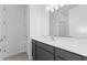 Bright bathroom features a large mirror, gray cabinets, and quartz countertop with integrated sink at 9596 Vibrant Lane, Venice, FL 34292