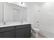 Bright bathroom features double sinks with gray cabinets and shower/tub combo with white tile surround at 9596 Vibrant Lane, Venice, FL 34292