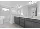 Modern bathroom with double vanity, gray cabinets, quartz counters, and glass-enclosed shower at 9596 Vibrant Lane, Venice, FL 34292