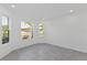 Bright bedroom with tile floors, two windows, and neutral paint at 9596 Vibrant Lane, Venice, FL 34292