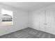 This bedroom offers neutral carpeting, white walls, and double doors for ample closet space at 9596 Vibrant Lane, Venice, FL 34292
