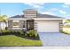 Beautiful single-story home featuring a two-car garage, gray brick driveway, and well-maintained landscaping at 9596 Vibrant Lane, Venice, FL 34292