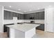 Modern kitchen featuring gray cabinets, a large white countertop island, and stainless steel appliances at 9596 Vibrant Lane, Venice, FL 34292