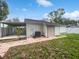 Backyard featuring a covered area for parking, storage shed, and brick path at 10344 Rosemount Dr, Tampa, FL 33624
