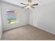 Bright bedroom with neutral carpet, a ceiling fan, a window overlooking the yard, and a closet at 10344 Rosemount Dr, Tampa, FL 33624
