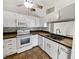 Well-lit kitchen featuring white cabinets, tile backsplash, and modern appliances at 10344 Rosemount Dr, Tampa, FL 33624