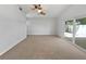 Spacious living room featuring carpet flooring, neutral paint, and a sliding door at 10344 Rosemount Dr, Tampa, FL 33624