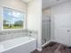 Bright bathroom with a large window, soaking tub, and glass-enclosed shower at 11126 Jenny Wren Rd, Weeki Wachee, FL 34614