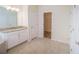 Stylish primary bathroom featuring granite countertops, dual sinks, and a walk-in closet for ample storage at 11818 Tetrafin Dr, Riverview, FL 33579