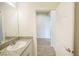 Bathroom with granite countertop vanity leading to hallway with wood-look flooring at 11818 Tetrafin Dr, Riverview, FL 33579