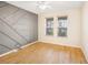 Bedroom with decorative accent wall, wood-look floors, and plenty of natural light at 11818 Tetrafin Dr, Riverview, FL 33579