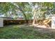 Large fenced backyard featuring mature trees, partial ground cover, and a brick area, offering privacy at 709 1St Ne Ave, Largo, FL 33770