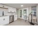 Modern kitchen with white cabinetry, stainless steel dishwasher, and a breakfast bar at 709 1St Ne Ave, Largo, FL 33770