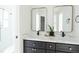 Bathroom featuring a double sink vanity with white countertop, black fixtures, and gold framed mirrors at 3920 Basswood Dr, Sarasota, FL 34232