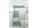 Cozy bathroom with light blue tiles, a tub, a shower, and white hexagon tile floor at 3920 Basswood Dr, Sarasota, FL 34232